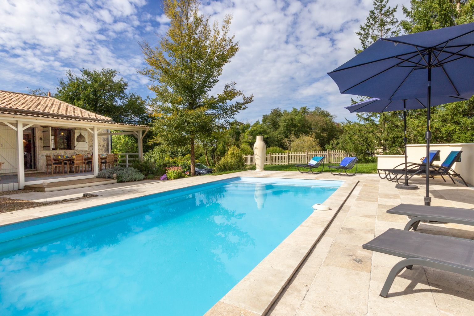 By the pool, the driveway parking is to the side of the house