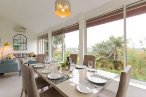 Open plan living area, dining table looking through to a seating area with wonderful views